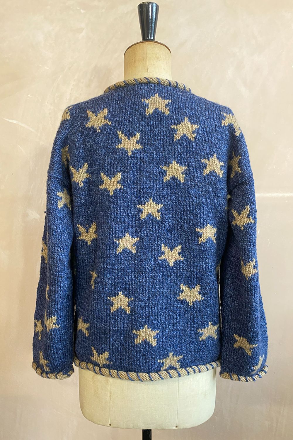 Back of Star Cardigan showing gold stars on blue background